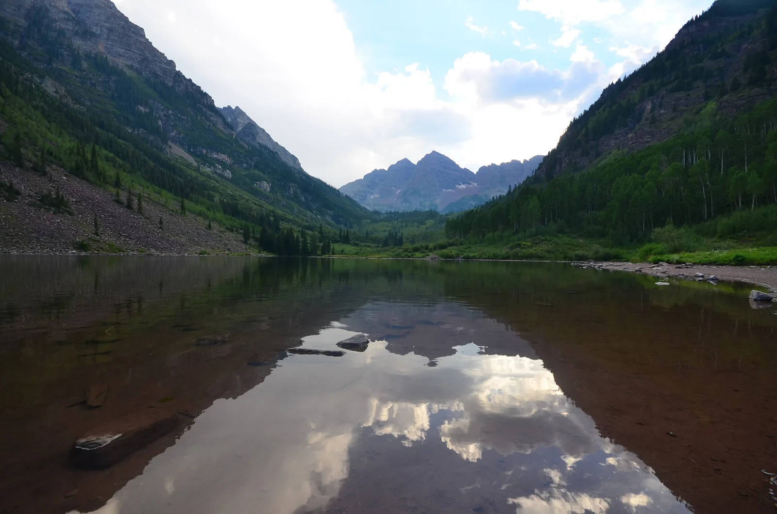 The Maroon Bells peaks reflected in calm Maroon Lake on a sunny summer day near Aspen, Colorado