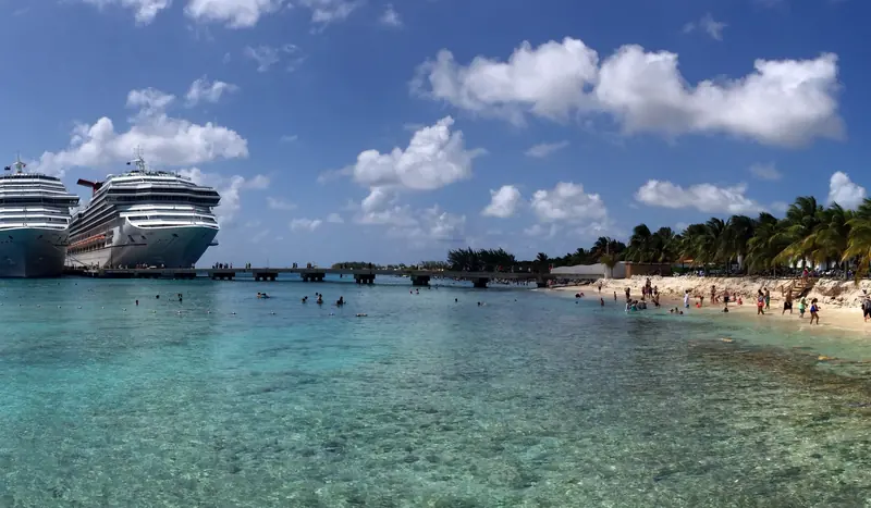 Cruise ships docked beside a white-sand beach and turquoise water on Grand Turk
