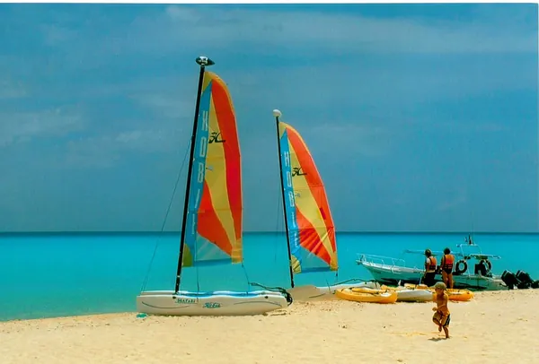 Colorful catamaran sails on the beach at Playa del Carmen