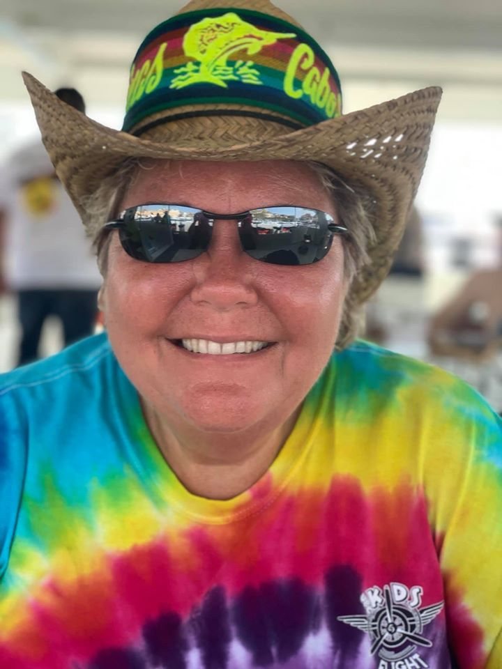 Karen Murphy, owner of Infinity Premier Travel, smiling in a straw Cabo hat