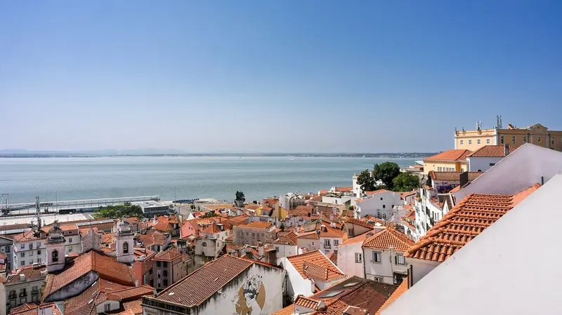 Red-tiled rooftops of Lisbon’s Alfama district above the Tagus River